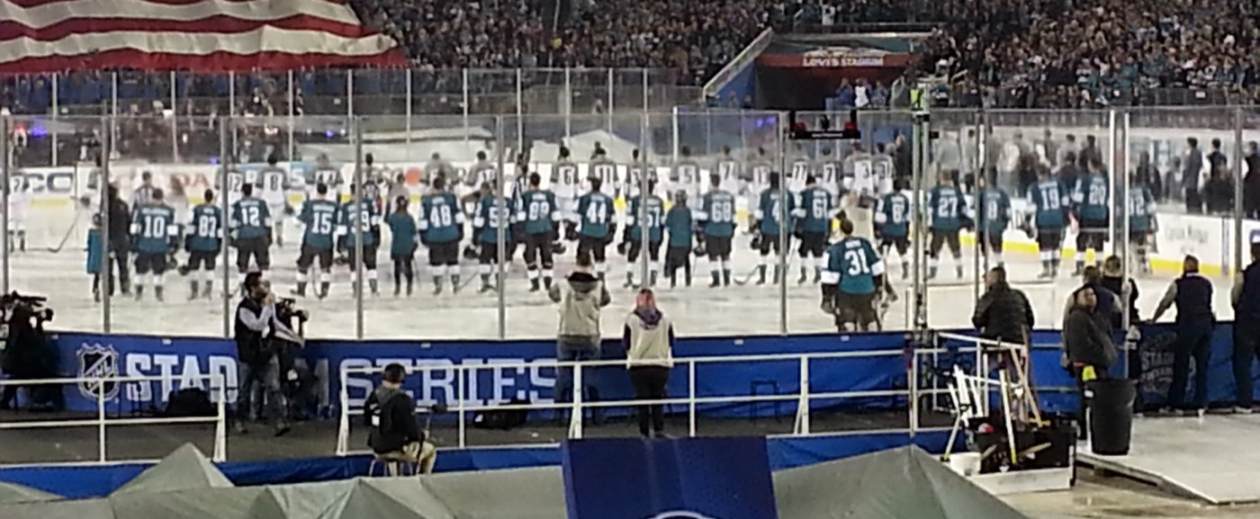 Outdoor NHL rink in a packed stadium under snowfall